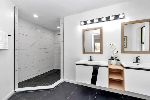 bathroom with tile patterned floors, vanity, and tiled shower