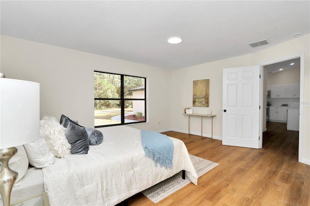 bedroom featuring hardwood / wood-style floors and a textured ceiling