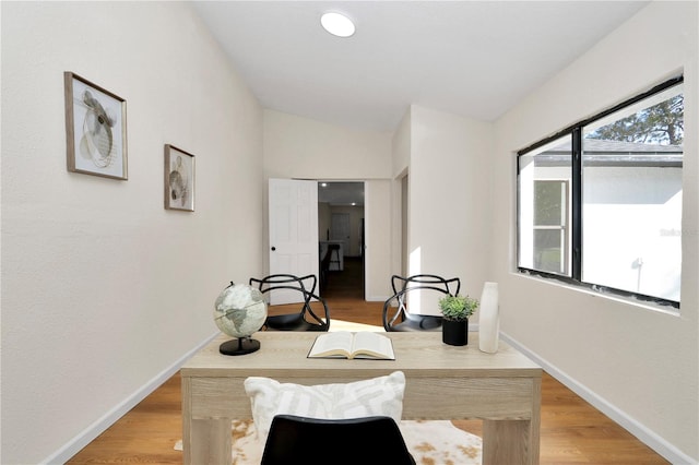 dining area featuring wood-type flooring and lofted ceiling