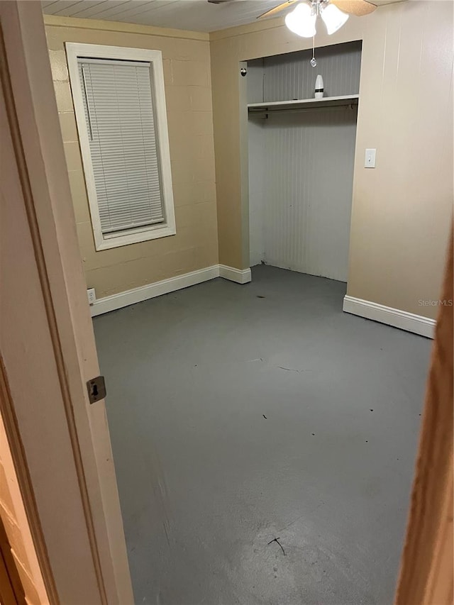 unfurnished bedroom with ceiling fan, a closet, and concrete flooring