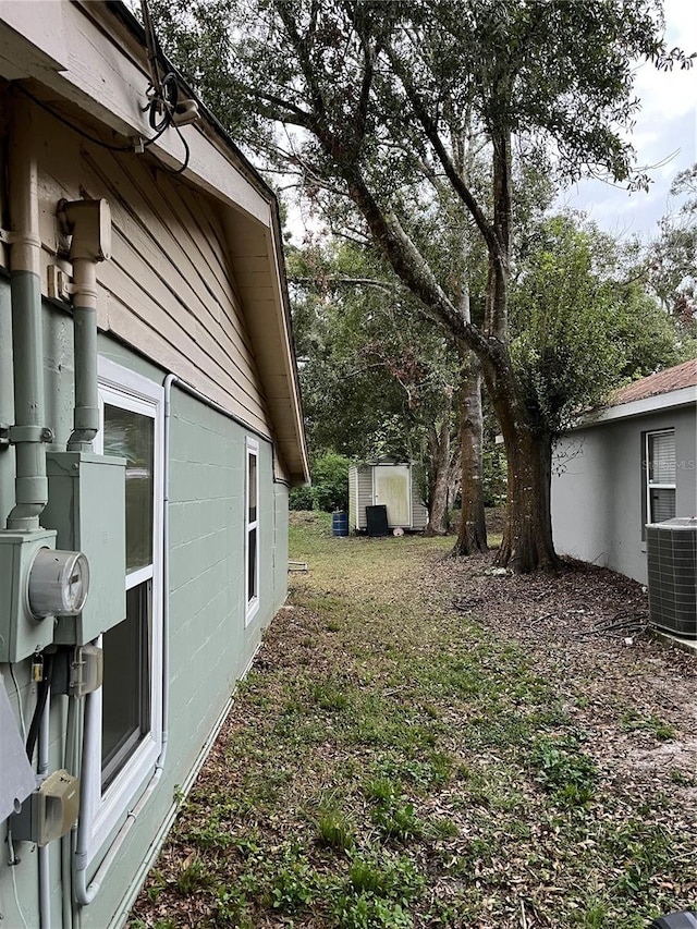 view of yard featuring a storage unit and cooling unit