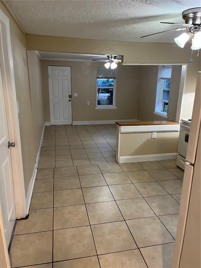 kitchen featuring white stove, light tile patterned floors, and a textured ceiling