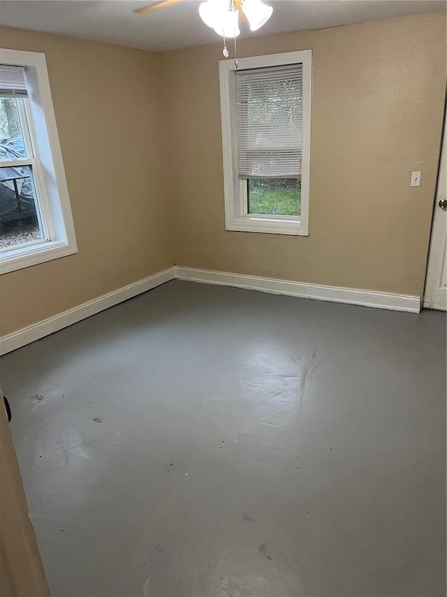 spare room featuring concrete floors and ceiling fan