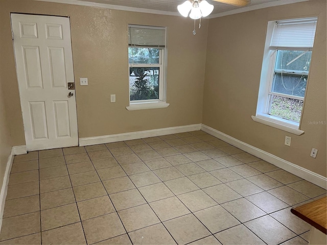 tiled spare room featuring a wealth of natural light, crown molding, and ceiling fan