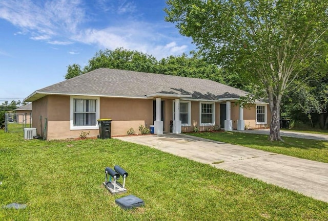 ranch-style home with central air condition unit and a front yard