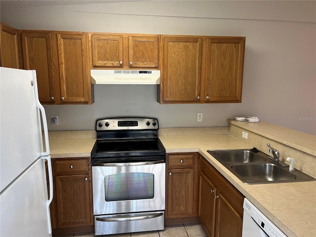 kitchen with light tile patterned flooring, white appliances, and sink