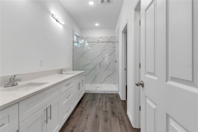 bathroom featuring hardwood / wood-style floors, vanity, and a shower with door