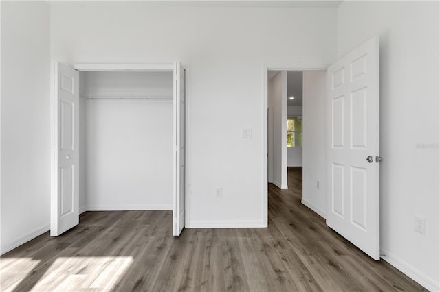 unfurnished bedroom featuring dark wood-type flooring and a closet