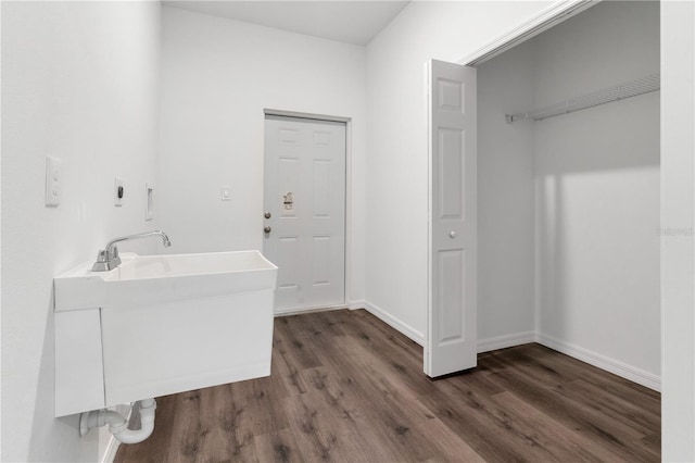 interior space with hookup for a washing machine, dark wood-type flooring, and sink