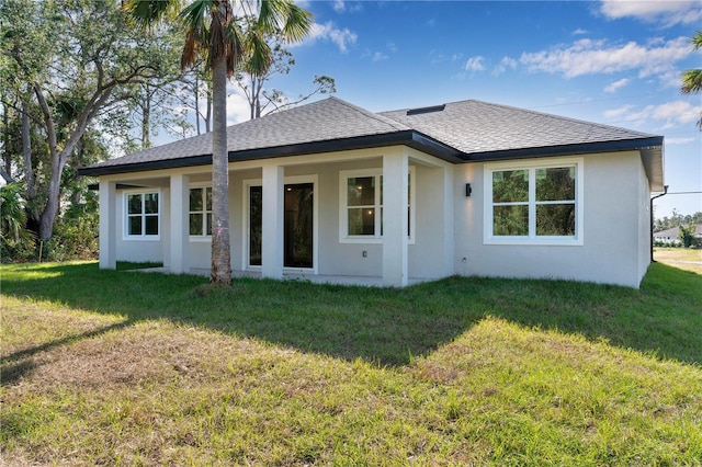 rear view of house featuring a lawn