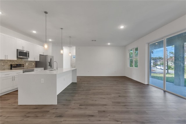 kitchen with white cabinetry, a kitchen island with sink, dark wood-type flooring, and appliances with stainless steel finishes