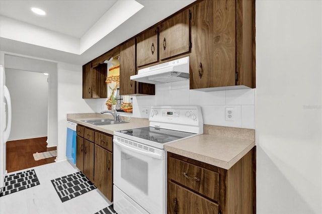 kitchen with wood-type flooring, white appliances, and sink