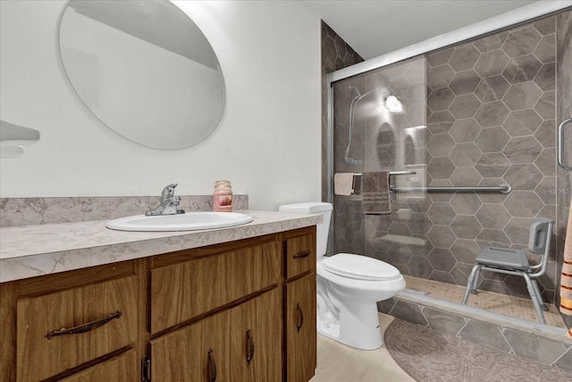 bathroom featuring vanity, a shower with shower door, and toilet