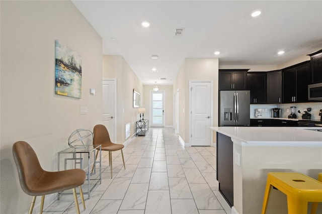 kitchen with backsplash, a kitchen bar, and stainless steel appliances