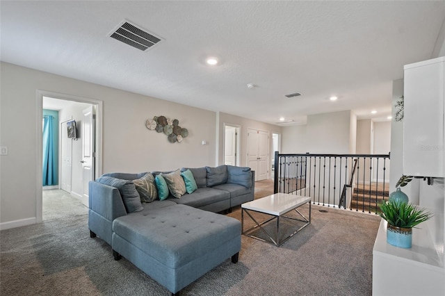 carpeted living room featuring a textured ceiling