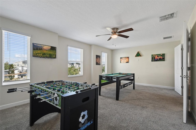 game room featuring carpet flooring, a textured ceiling, and ceiling fan