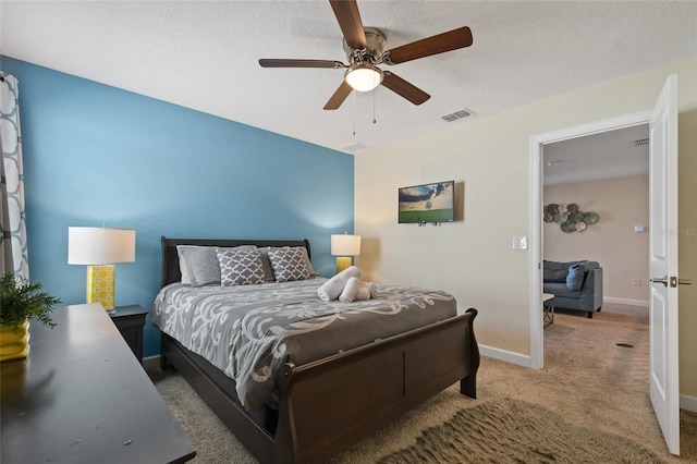 carpeted bedroom featuring ceiling fan and a textured ceiling