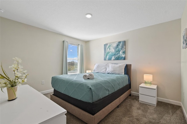 bedroom featuring dark colored carpet and a textured ceiling