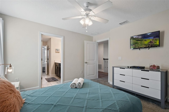 bedroom featuring connected bathroom, ceiling fan, carpet, and a textured ceiling