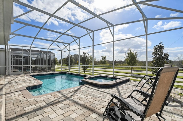 view of swimming pool with a lanai, a patio area, and an in ground hot tub