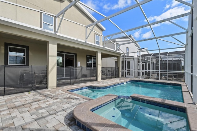 view of swimming pool featuring an in ground hot tub, a patio, and glass enclosure