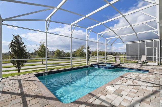 view of pool featuring an in ground hot tub, a patio, and glass enclosure