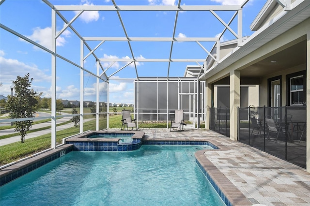 view of pool featuring a patio area, a lanai, and an in ground hot tub