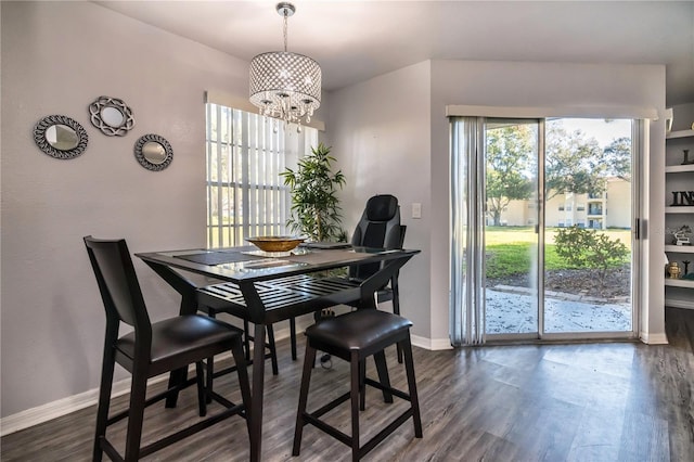 dining space featuring dark wood-type flooring and a notable chandelier