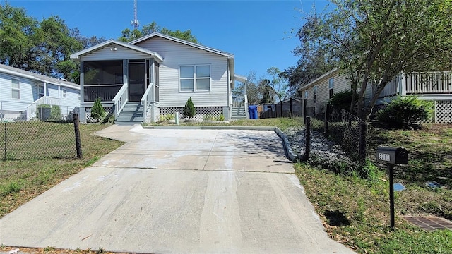 manufactured / mobile home with a sunroom and a front yard