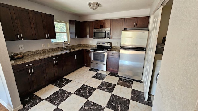 kitchen featuring light stone countertops, sink, dark brown cabinets, and appliances with stainless steel finishes