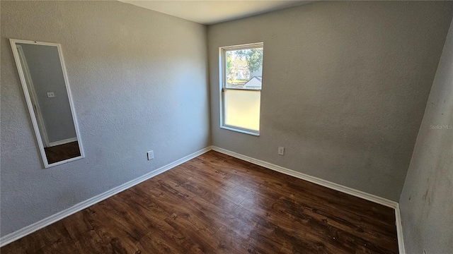 spare room featuring dark wood-type flooring