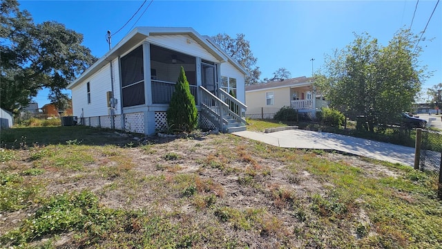 rear view of house featuring a yard and a sunroom