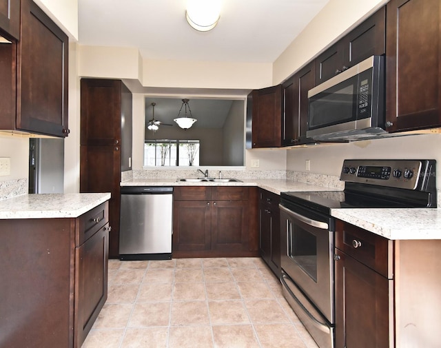 kitchen featuring appliances with stainless steel finishes, dark brown cabinetry, vaulted ceiling, and hanging light fixtures