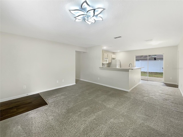 unfurnished living room with carpet and sink