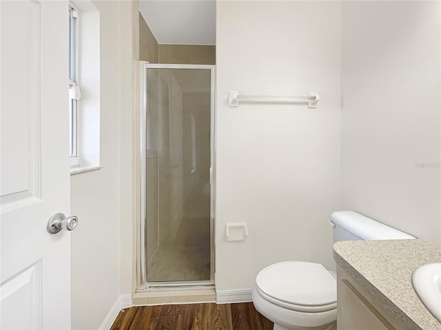 bathroom with vanity, hardwood / wood-style flooring, toilet, and a shower with door