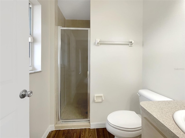 bathroom featuring hardwood / wood-style floors, vanity, an enclosed shower, and toilet