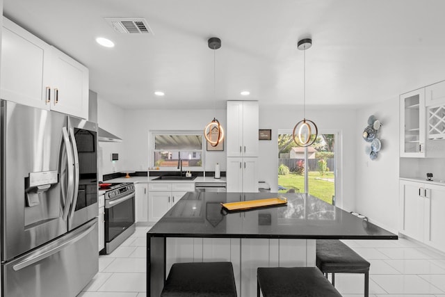 kitchen featuring a breakfast bar area, a wealth of natural light, a center island, and appliances with stainless steel finishes