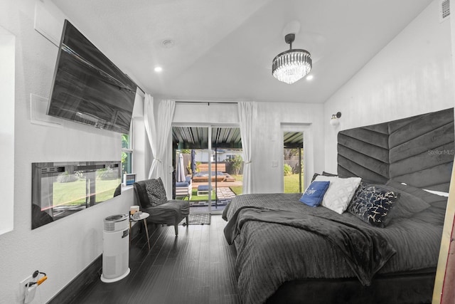 bedroom with wood-type flooring, lofted ceiling, and a notable chandelier