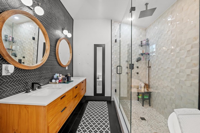 bathroom with tile patterned flooring, vanity, a shower with door, and tile walls