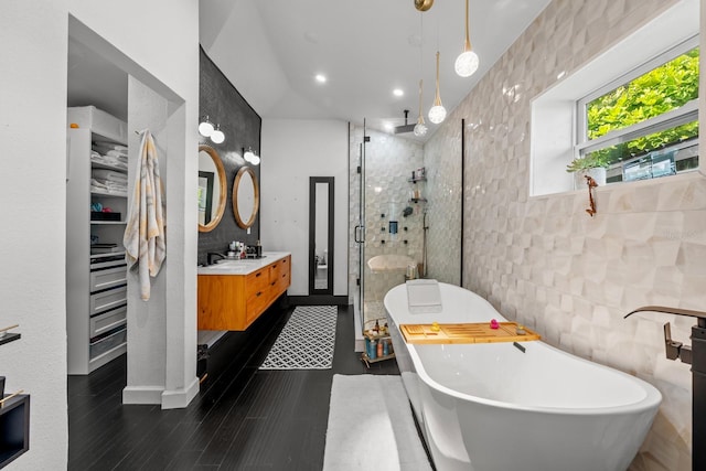 bathroom featuring vanity, tile walls, and independent shower and bath