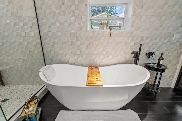 bathroom featuring a bathtub, tile walls, and tile patterned flooring