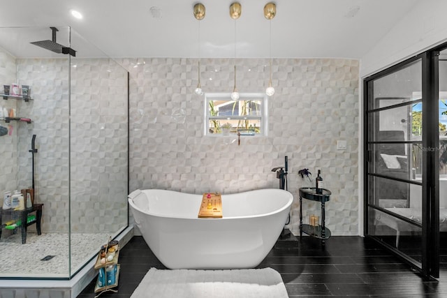 bathroom featuring shower with separate bathtub and tile walls