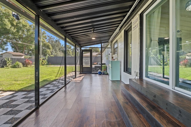 unfurnished sunroom featuring vaulted ceiling