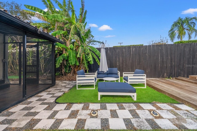 view of yard with outdoor lounge area, a patio area, a sunroom, and a deck