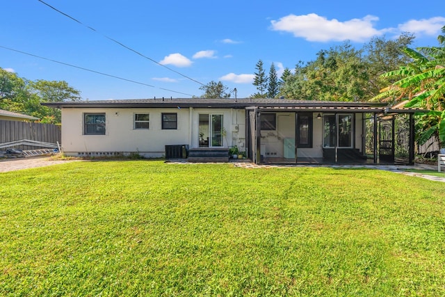 back of property with a yard, central AC, and a sunroom