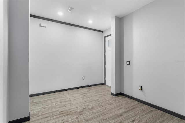 spare room featuring light hardwood / wood-style floors and ornamental molding