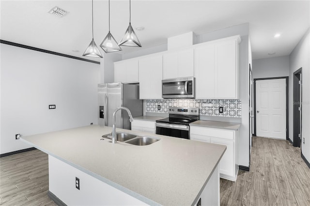 kitchen with light wood-type flooring, stainless steel appliances, white cabinetry, and a kitchen island with sink