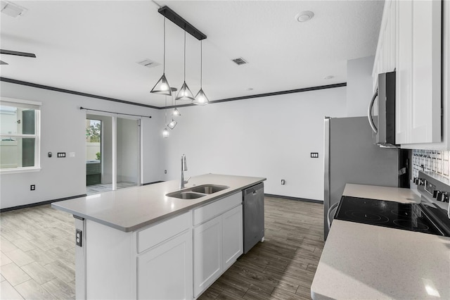 kitchen featuring stainless steel appliances, a kitchen island with sink, sink, decorative light fixtures, and white cabinetry