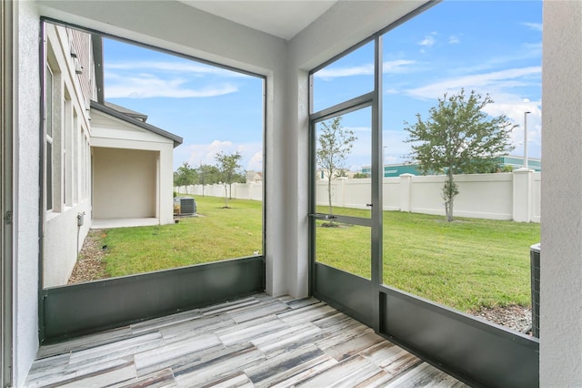 unfurnished sunroom with plenty of natural light and a water view