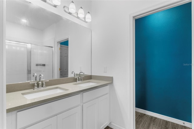 bathroom with a shower with door, vanity, and hardwood / wood-style floors